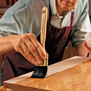 Lacka med pensel på en plan yta med flat lackpensel